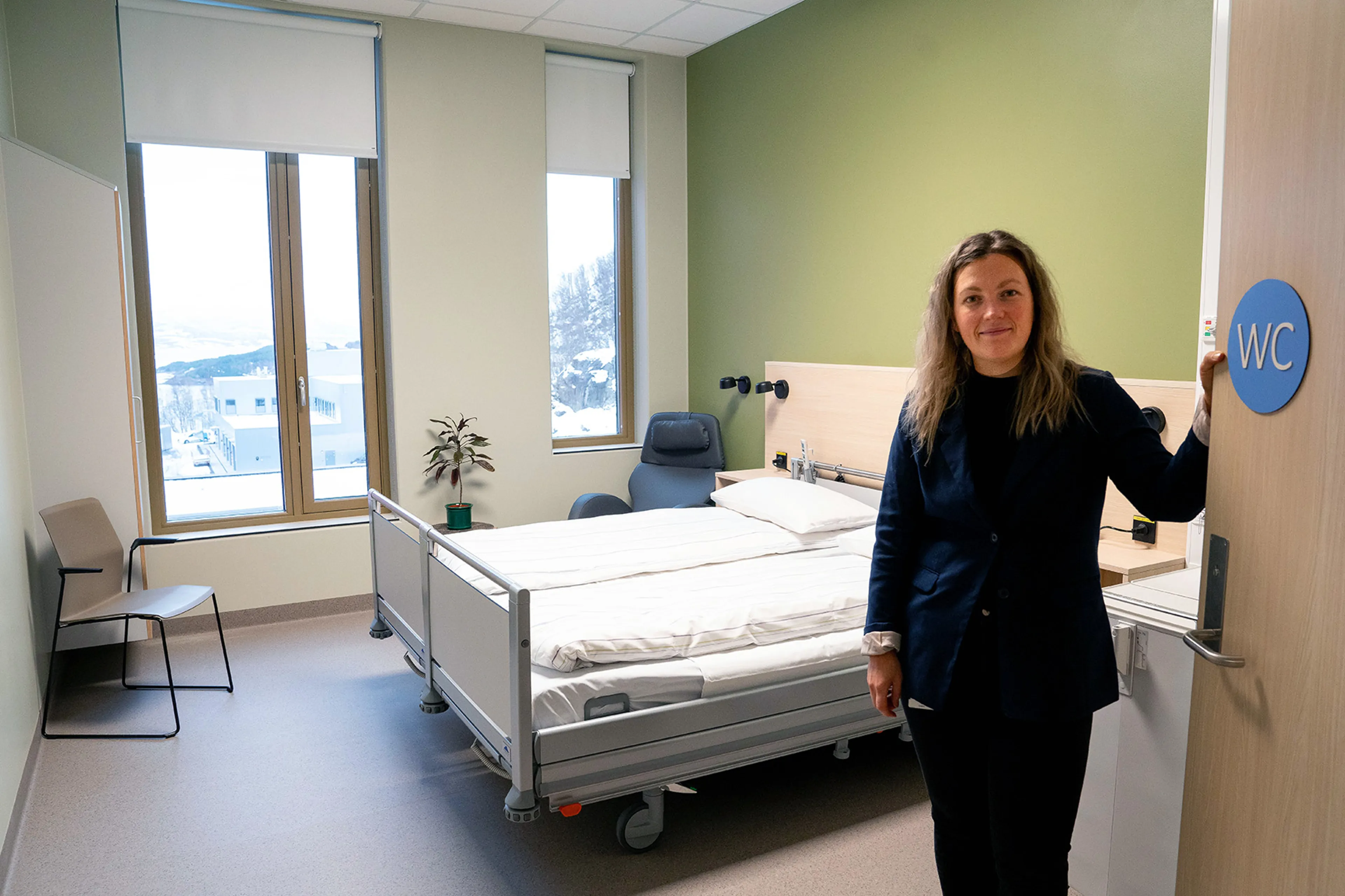 En kvinne som står ved siden av en seng