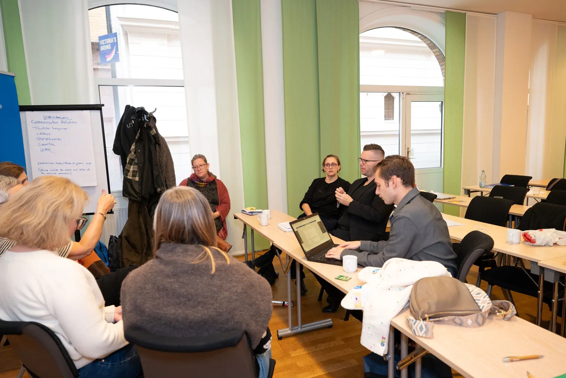 En gruppe mennesker som sitter ved bord