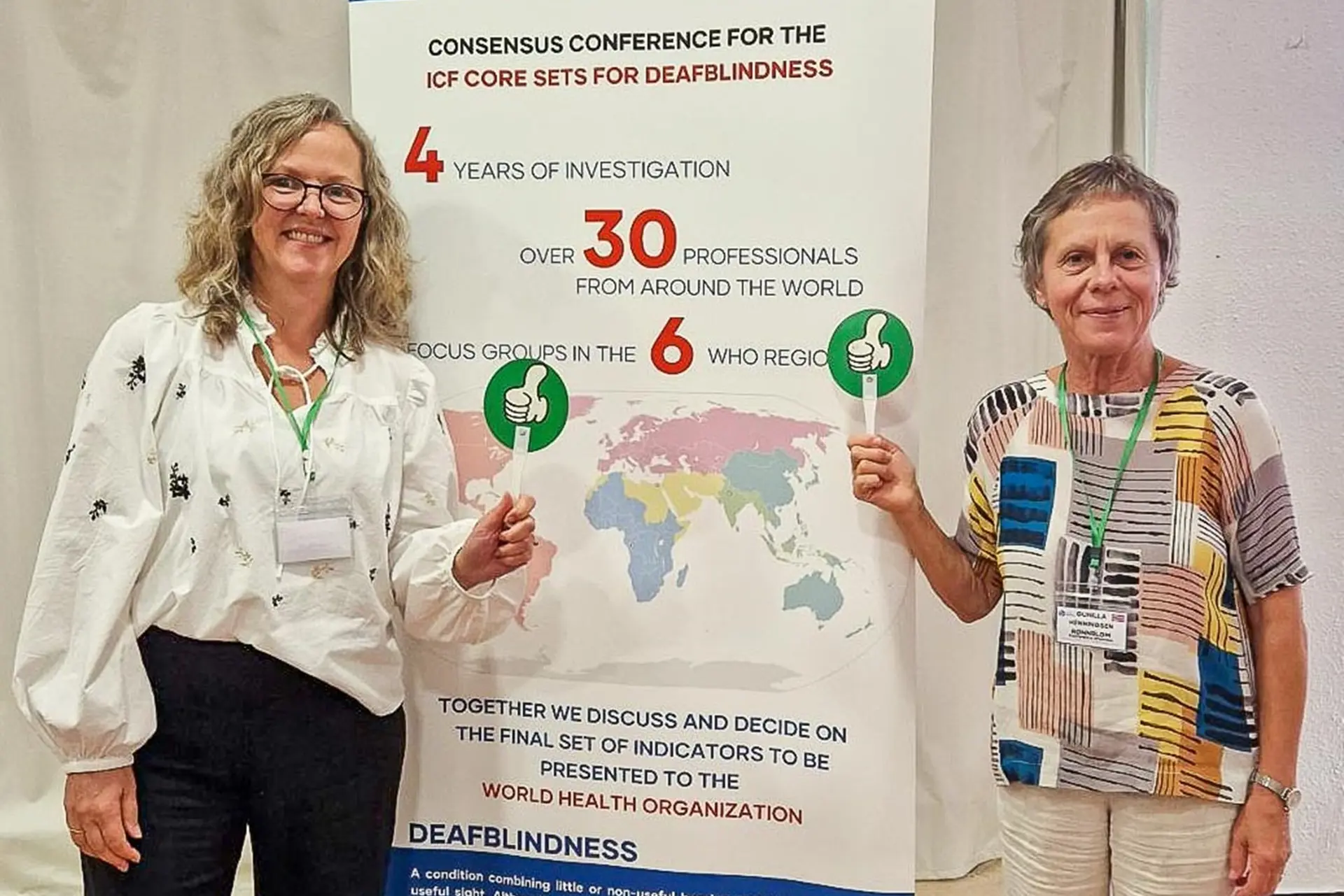 To personer som står ved siden av en poster