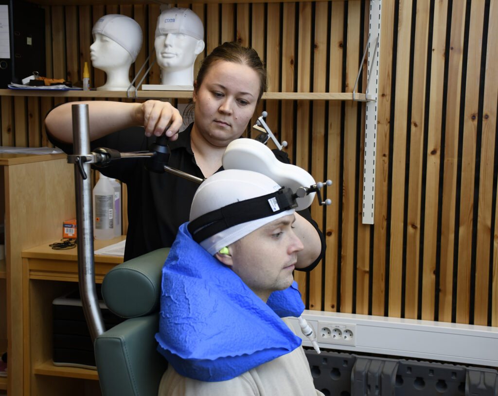 En person med maske på hodet ved siden av en person med pistol