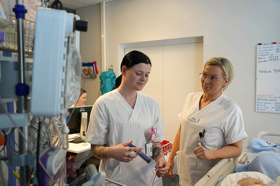 To kvinner inne på pasientrom kontrollerer sonde