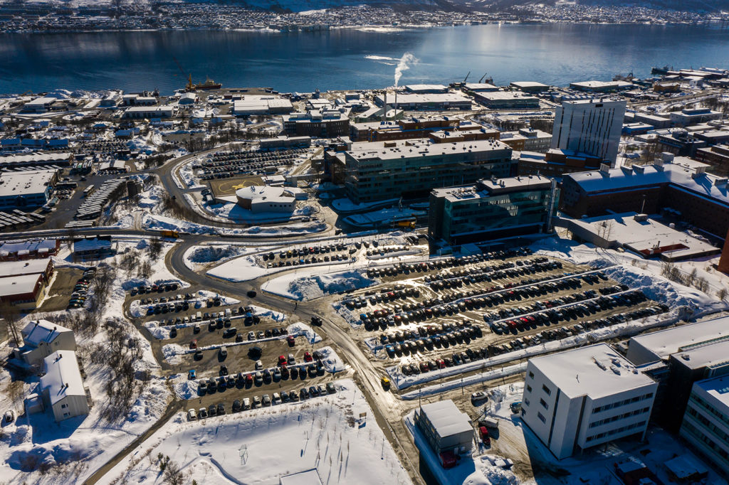 En by med mange bygninger og en vannmasse i bakgrunnen