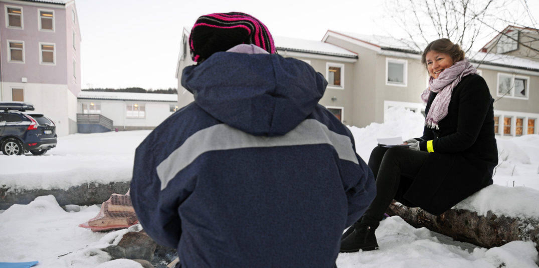 En person som sitter på en bil med et teppe på ryggen