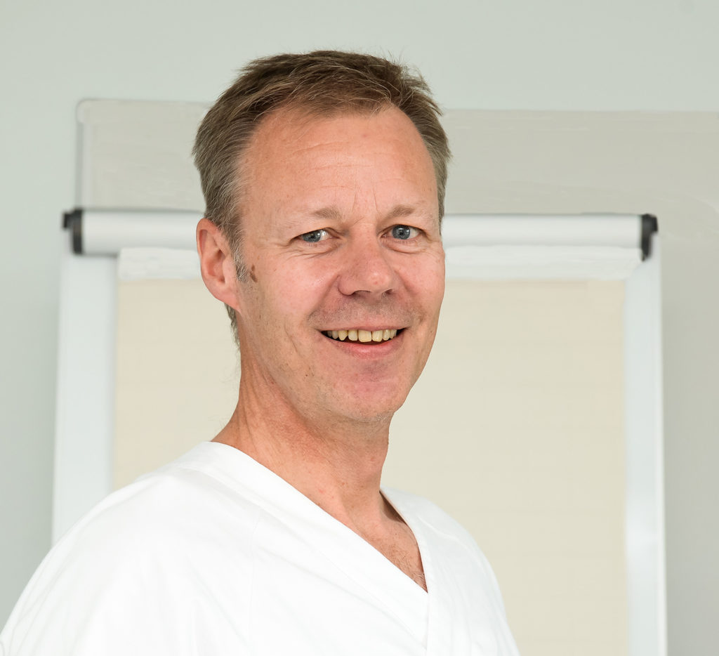 En mann som smiler til kameraet