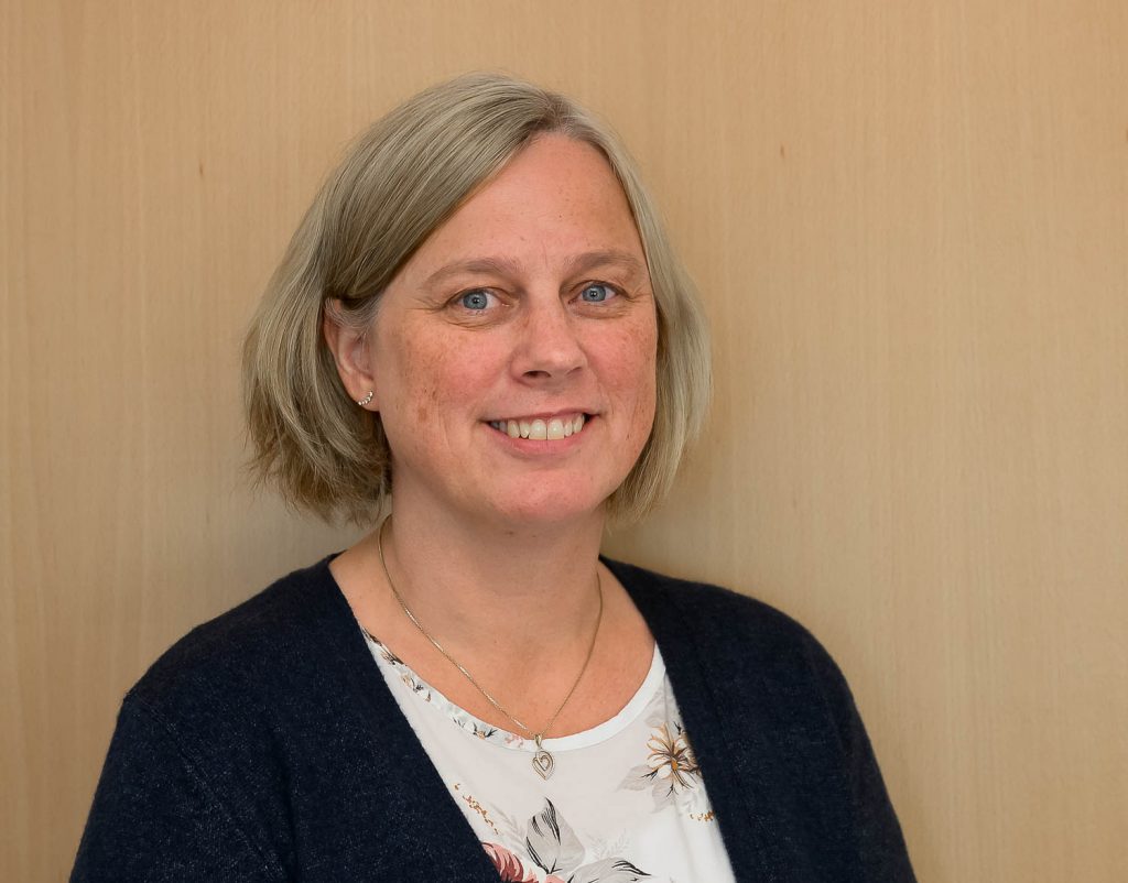 En kvinne som smiler til kameraet