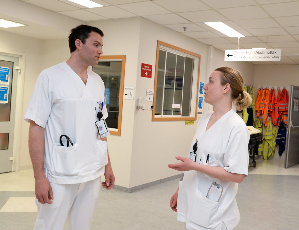 En mann og en kvinne i hvite uniformer i et rom