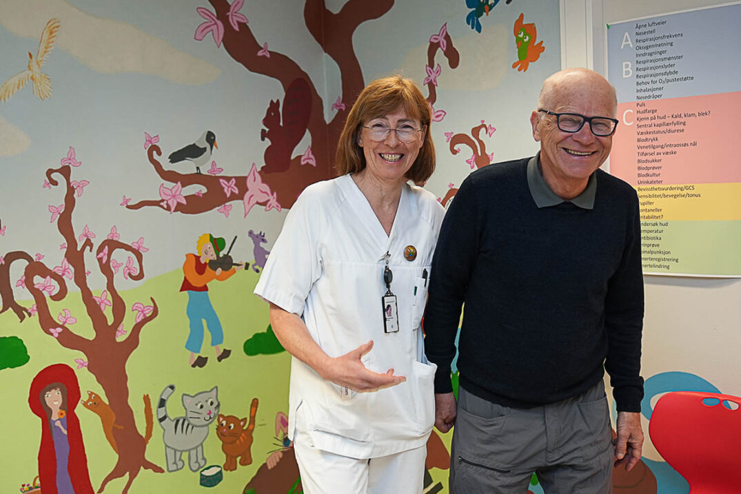 Mann og dame foran vegg med barnemotiver