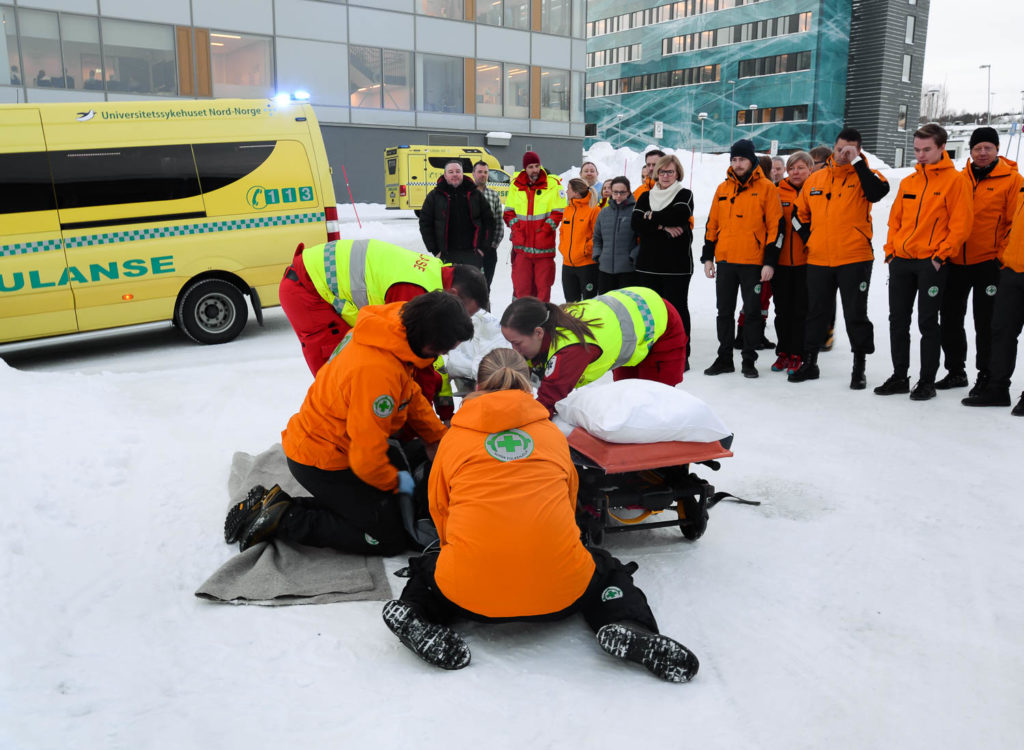 En gruppe mennesker i oransje jakker