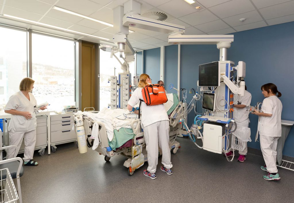 En gruppe kvinner i hvite frakker i et rom med medisinsk utstyr