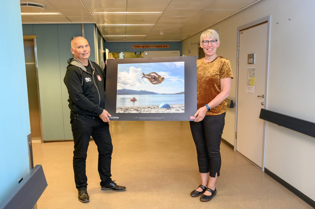 En mann og en kvinne som står i en korridor med en stor skjerm