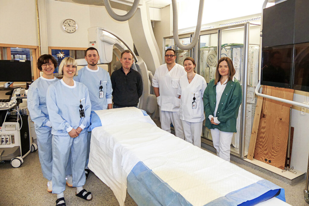 Syv personer rund en sykeseng/røngtenmaskin