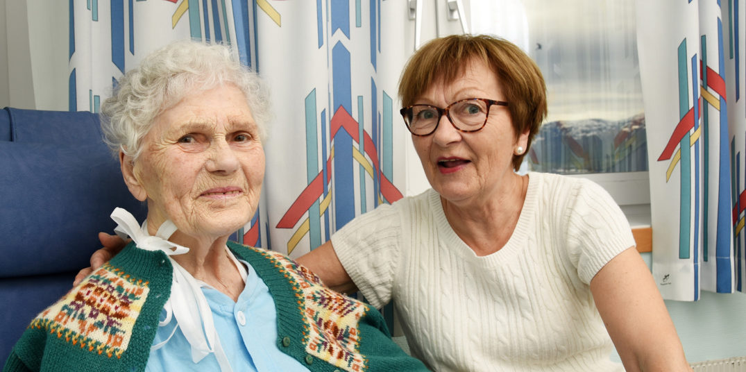 Et par kvinner som sitter i en sofa