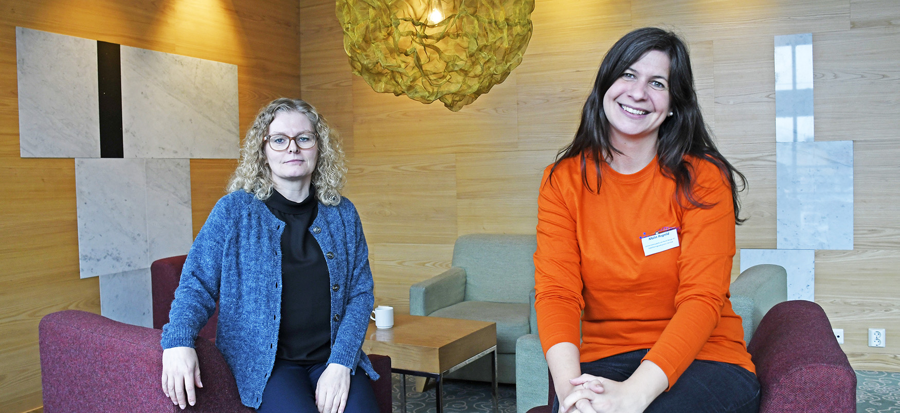 Et par kvinner som sitter i en sofa