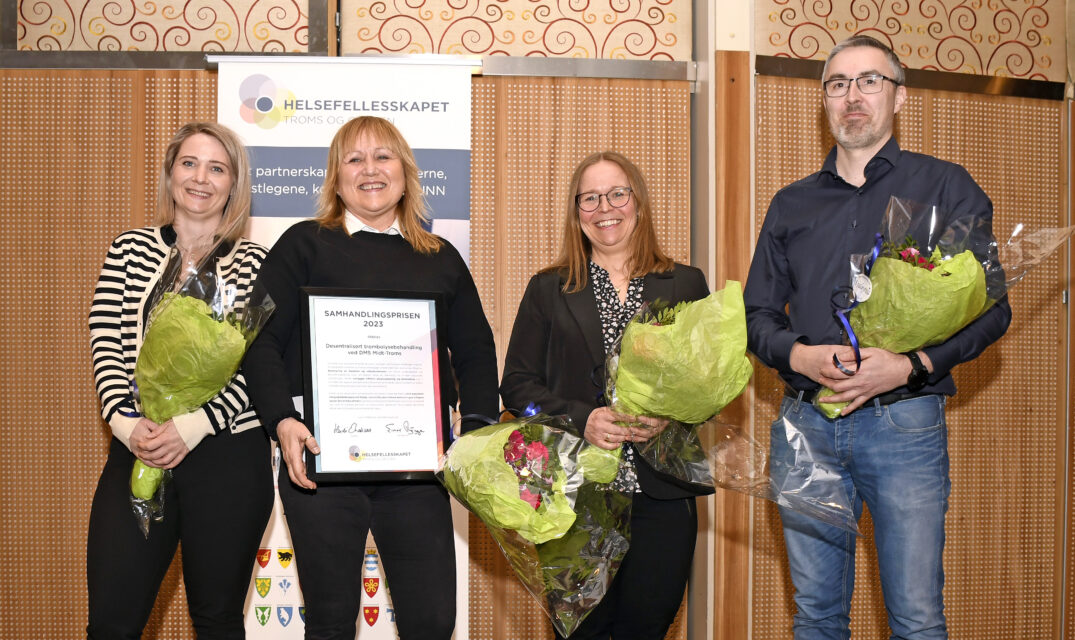 Tre personer som holder blomster og en person holder en diplom