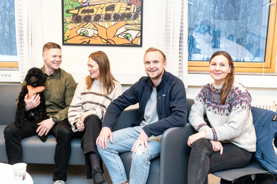 Fire personer i utadrettet team pluss en hund