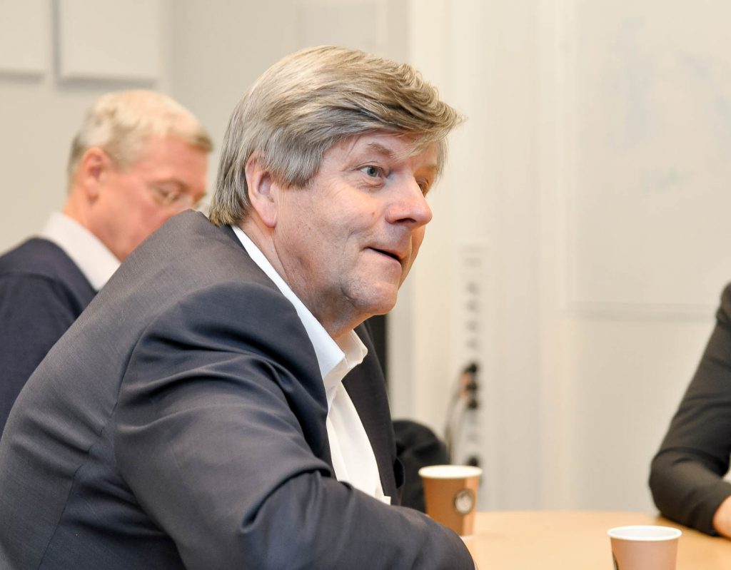 En person i dress som sitter ved et bord