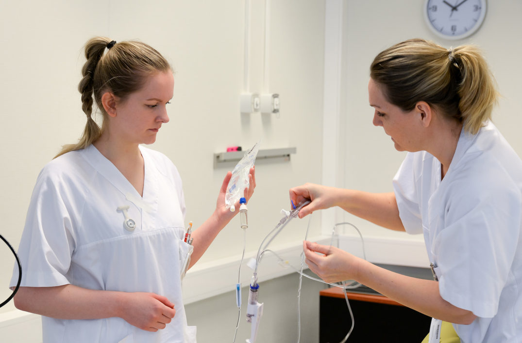 En lege som sjekker en pasients puls