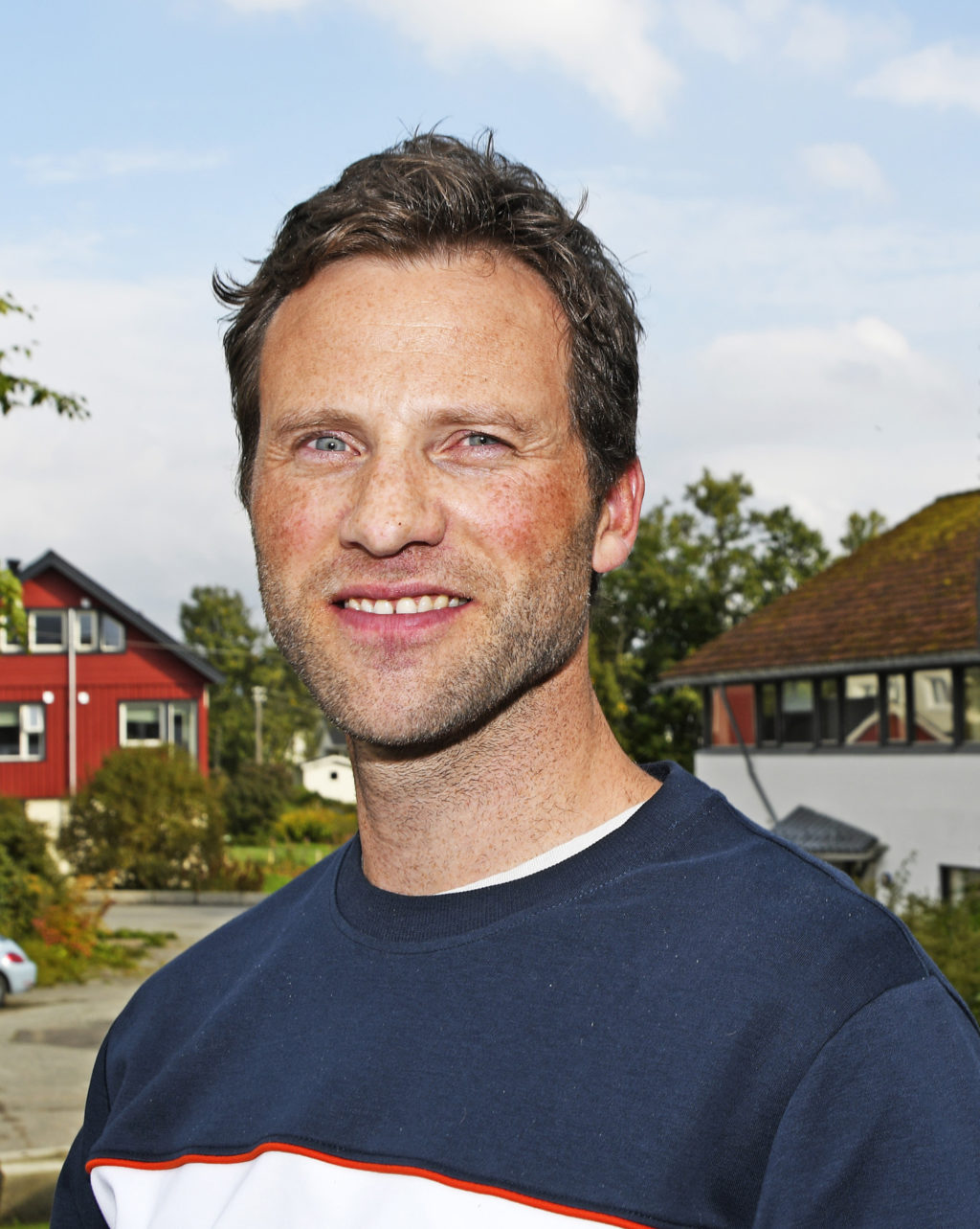 En mann som smiler til kameraet