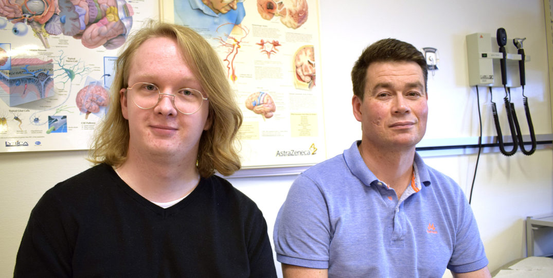 En mann og en kvinne i et rom med plakater på veggen