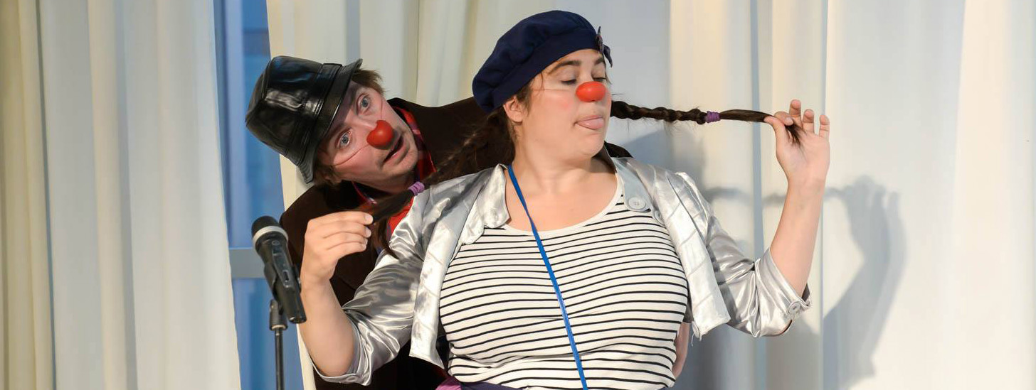 En kvinne med mikrofon og en kvinne med rød nese