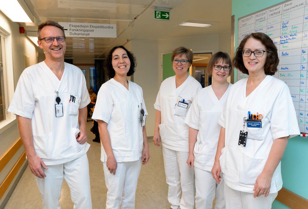 En gruppe mennesker iført hvite laboratoriefrakker