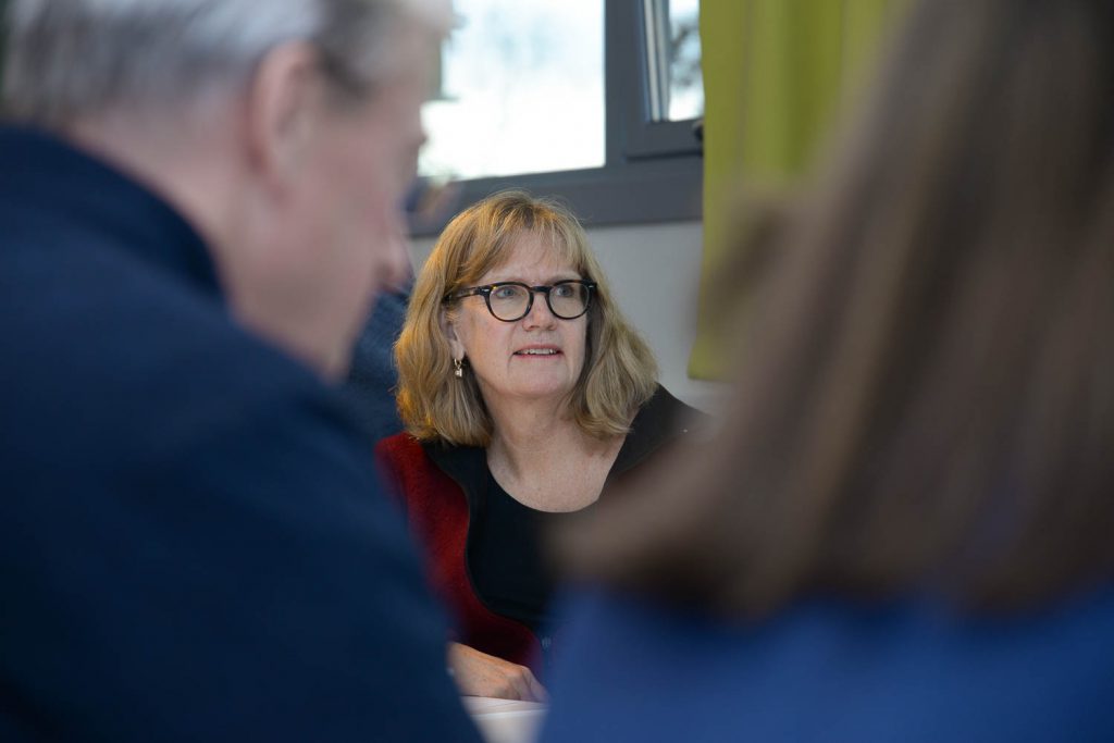 En kvinne med briller som snakker med en mann