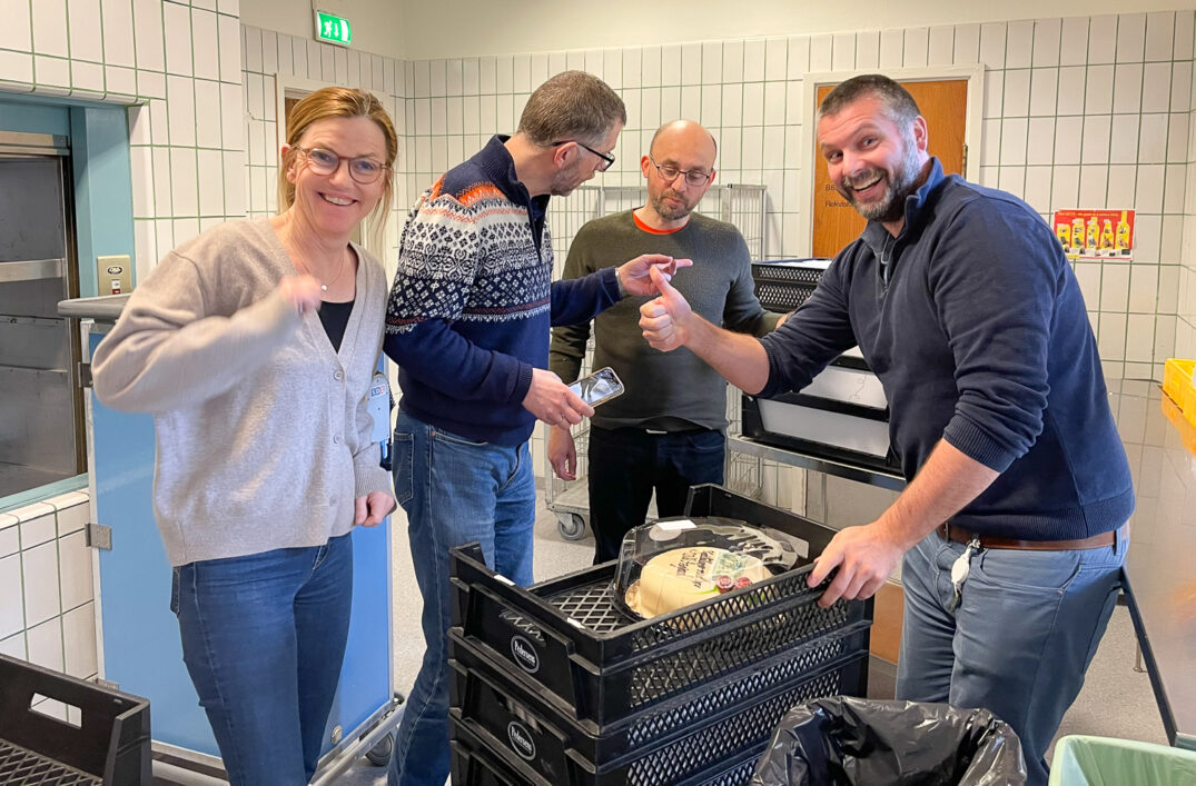 En gruppe mennesker som står rundt en grill med mat på