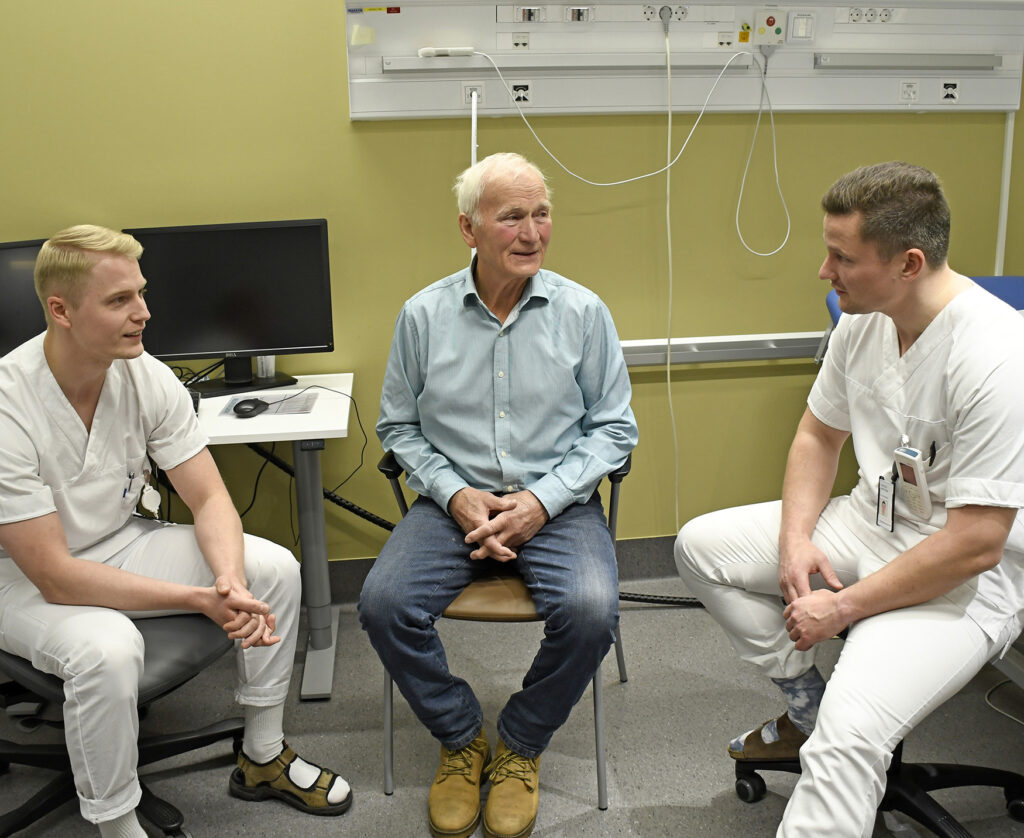 En gruppe menn som sitter i stoler