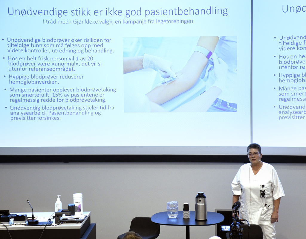 En mann som står foran en stor skjerm