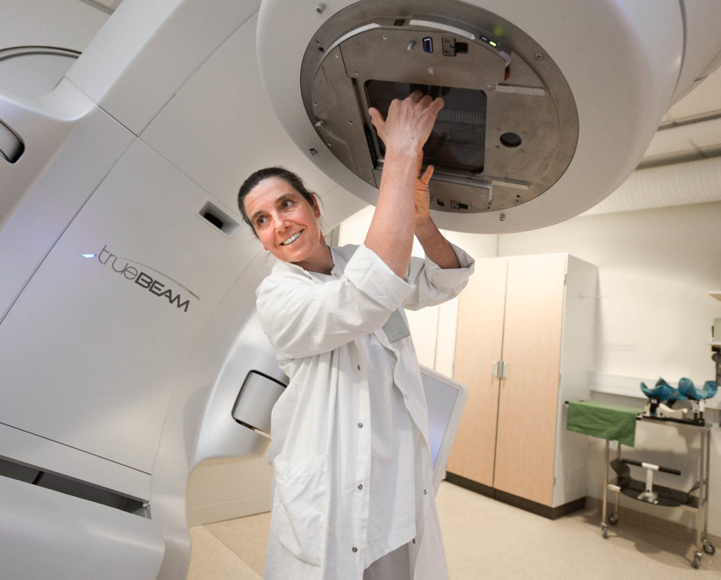 En person i hvit laboratoriefrakk som holder en stor maskin