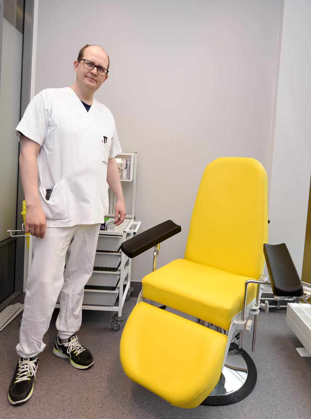 En mann som står ved siden av en stol