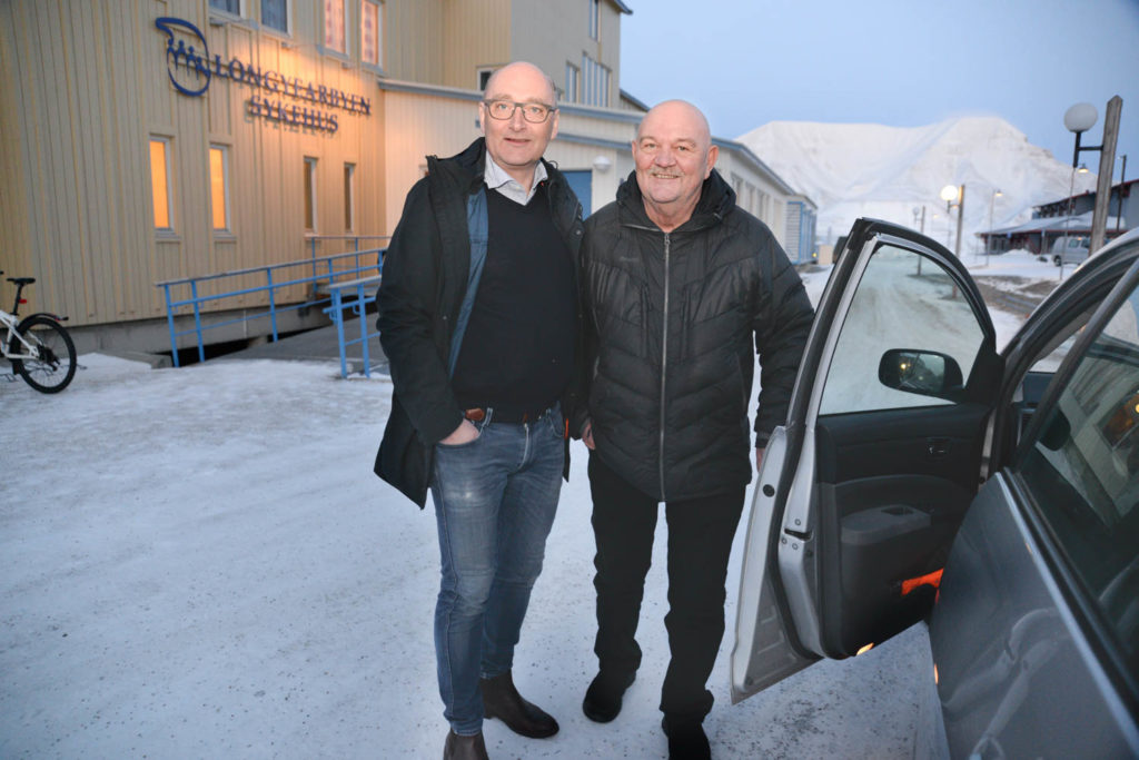 To menn som står ved siden av en bil