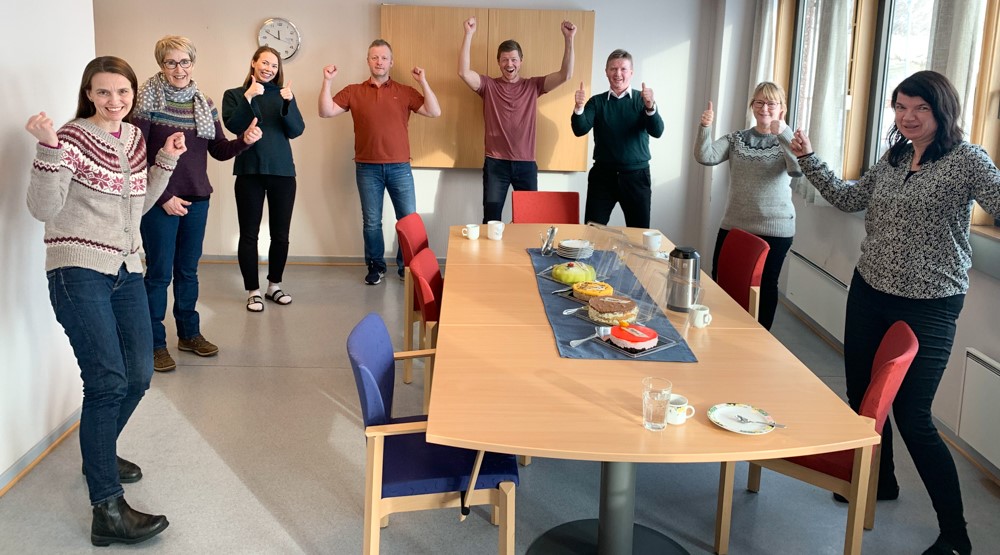 En gruppe mennesker som står rundt et bord med mat på