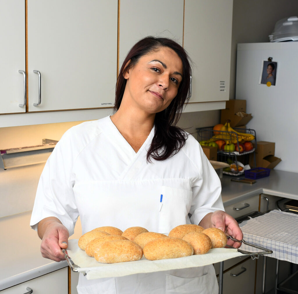 En kvinne som holder et brett med mat