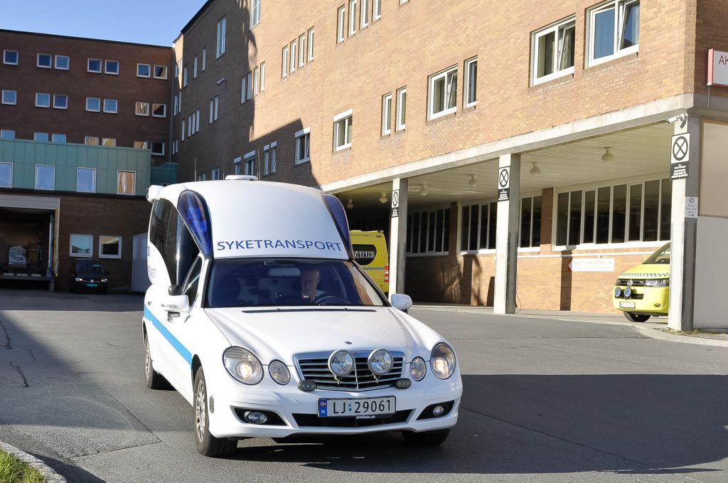 En hvit bil parkert foran en bygning