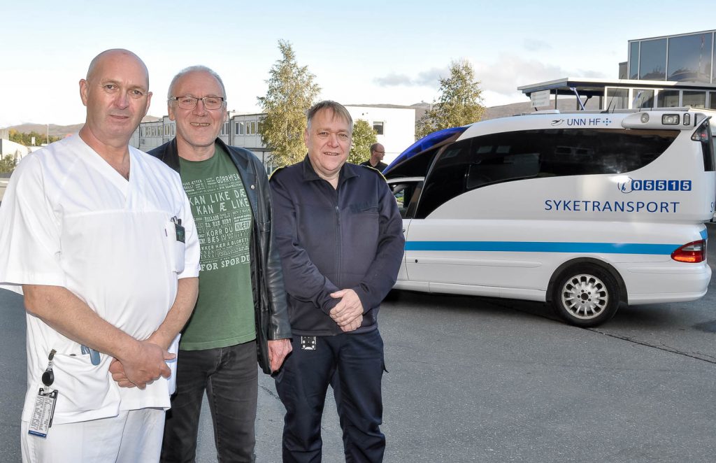 En gruppe menn poserer for et bilde foran en politibil