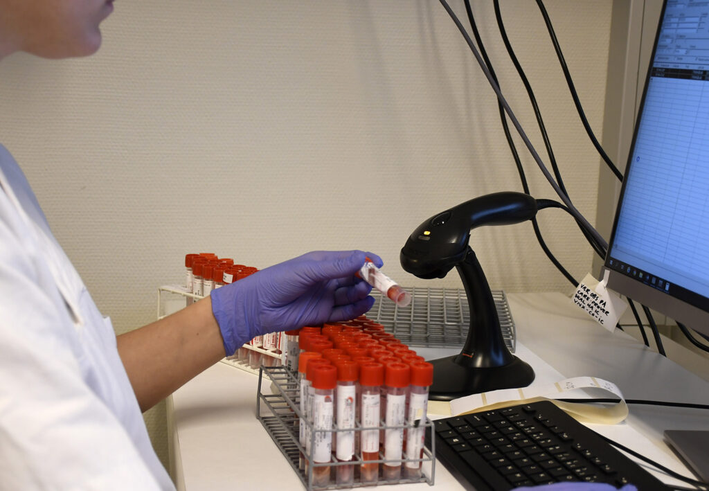 En person i laboratoriefrakk som bruker en datamaskin