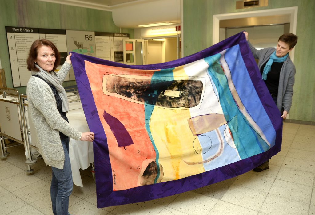 En person som står ved siden av et maleri