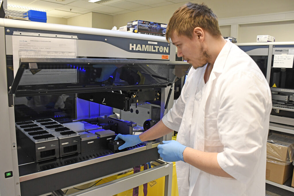 En mann i hvit frakk som jobber på en fabrikk