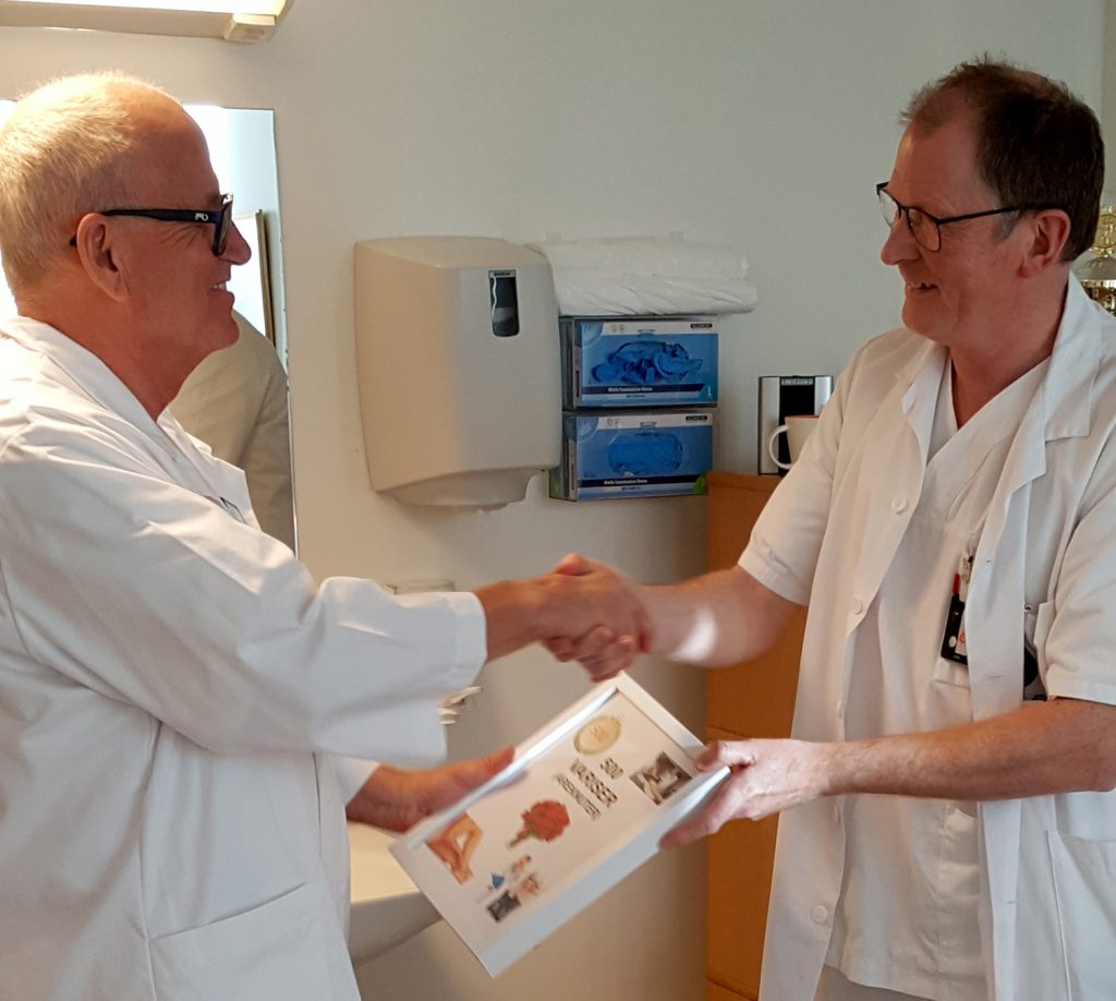 En lege som viser en pasient noe på papiret