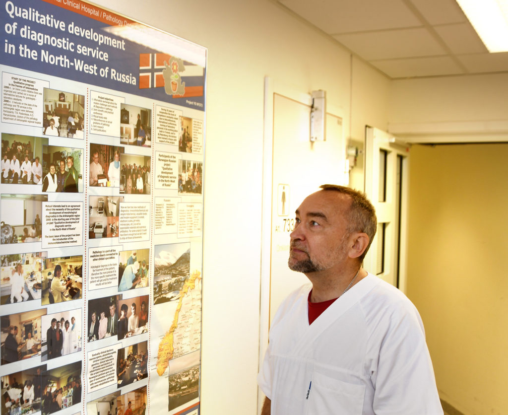 En mann som står foran en plakat