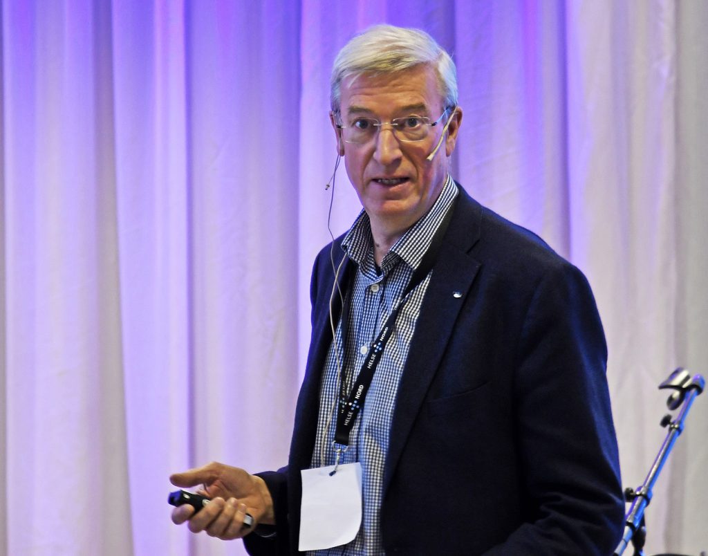 En mann i dress som snakker inn i en mikrofon