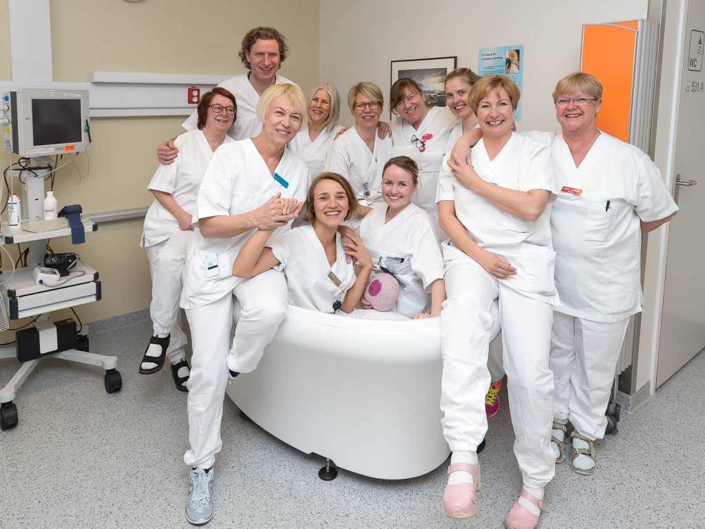 En gruppe mennesker i hvite laboratoriefrakker poserer for et bilde