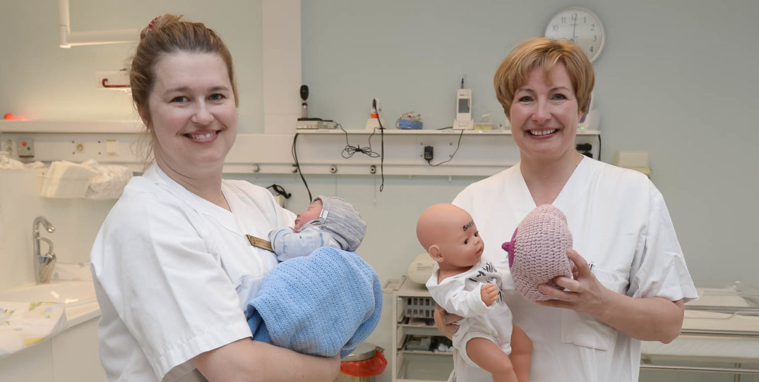 Et par kvinner som holder en baby