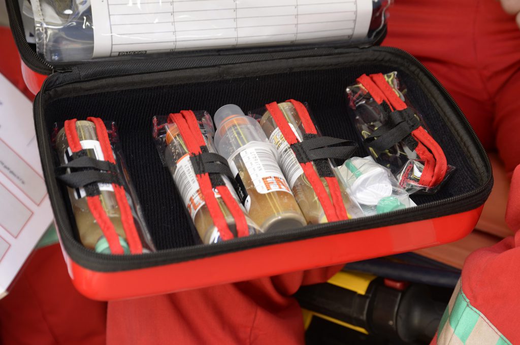 En rød koffert full av flasker