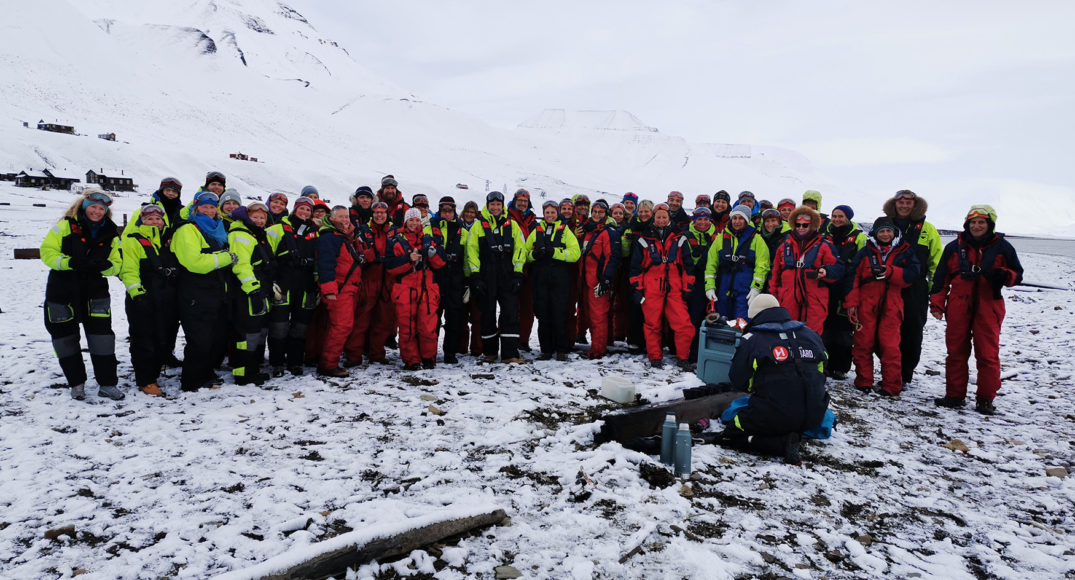 En gruppe mennesker som står på en snødekt ås
