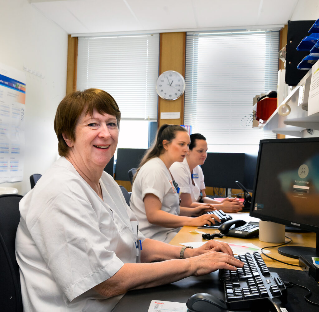 En gruppe mennesker som sitter ved et skrivebord