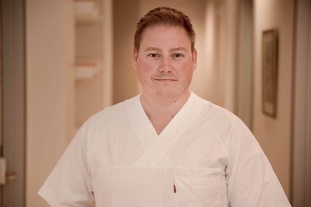 En mann iført hvit skjorte