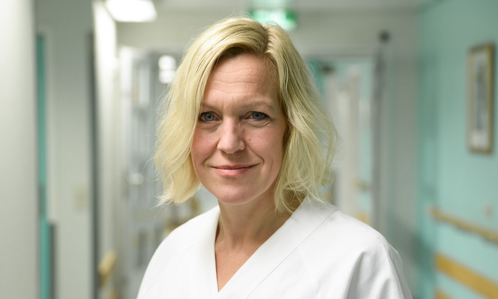 En kvinne som smiler til kameraet