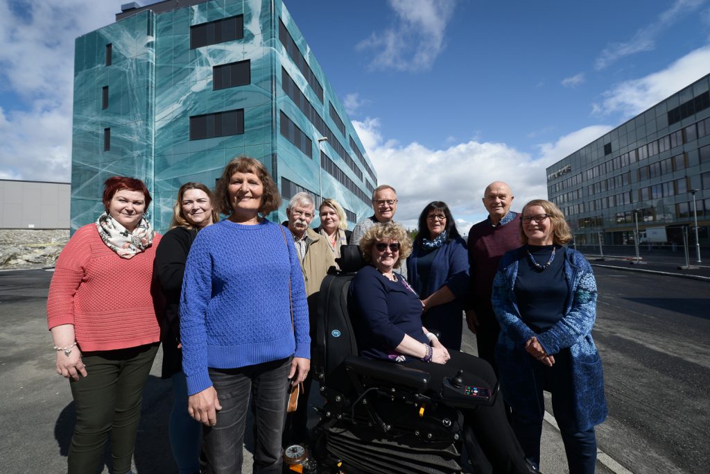 En gruppe mennesker som poserer for et bilde foran en bygning